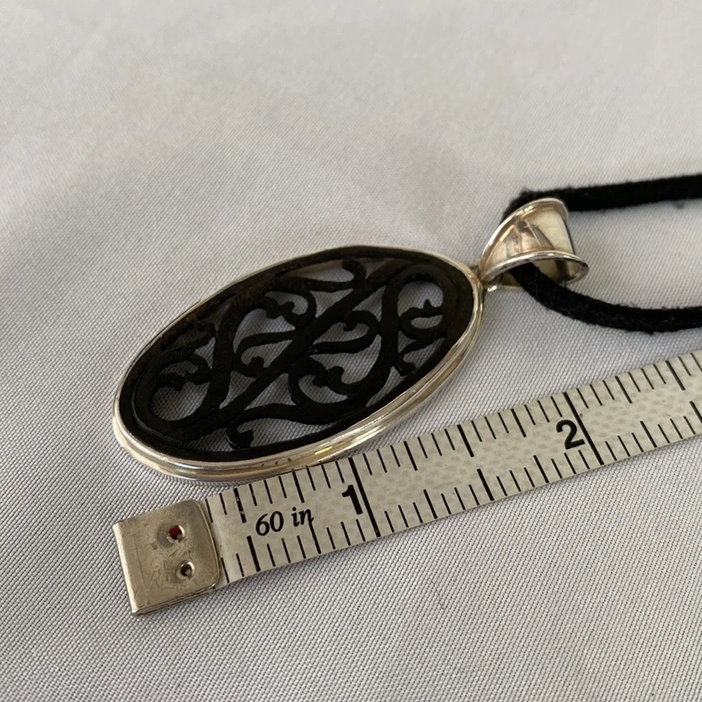 Carved wood pendant 925 on black cord
